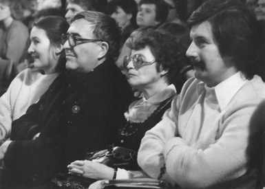 Fekete-fehér archív fotó: négy ember egymás mellett ülve néz figyelmesen valamilyen előadást. Balról egy fiatal nő, mellette szemüveges férfi, középen idősebb nő, jobb szélen fiatal férfi bajusszal.